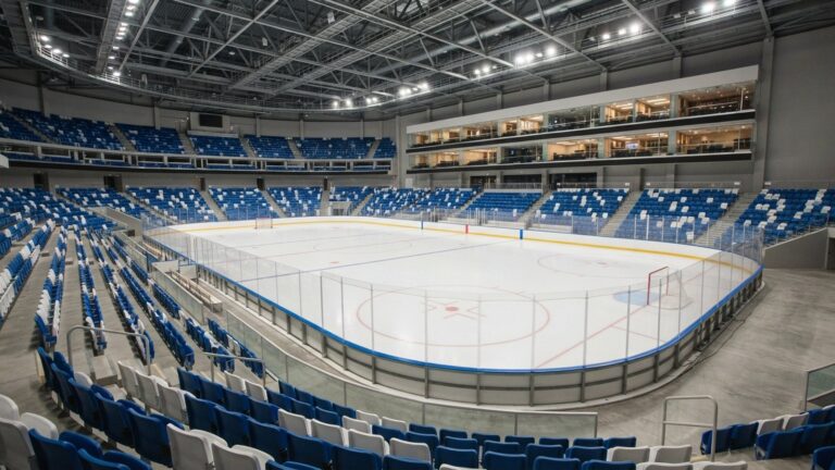Moderní hokejová hala s modrobílými sedačkami a skyboxy