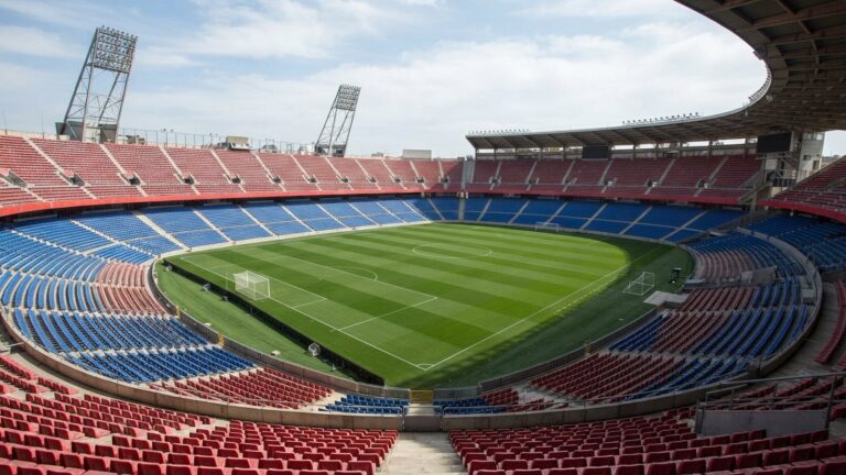 Prázdný fotbalový stadion s červenomodrými sedačkami